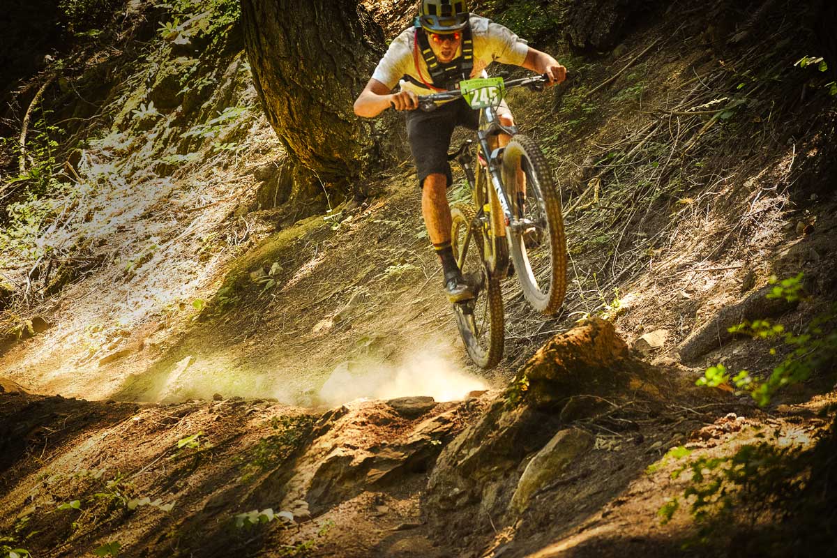 Racer jumping off rock on trail