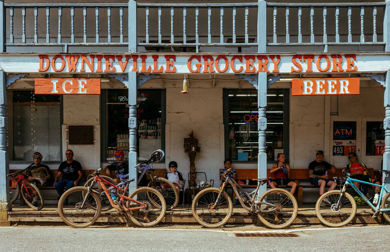 People sitting on porch of the Downieville Grocery Store